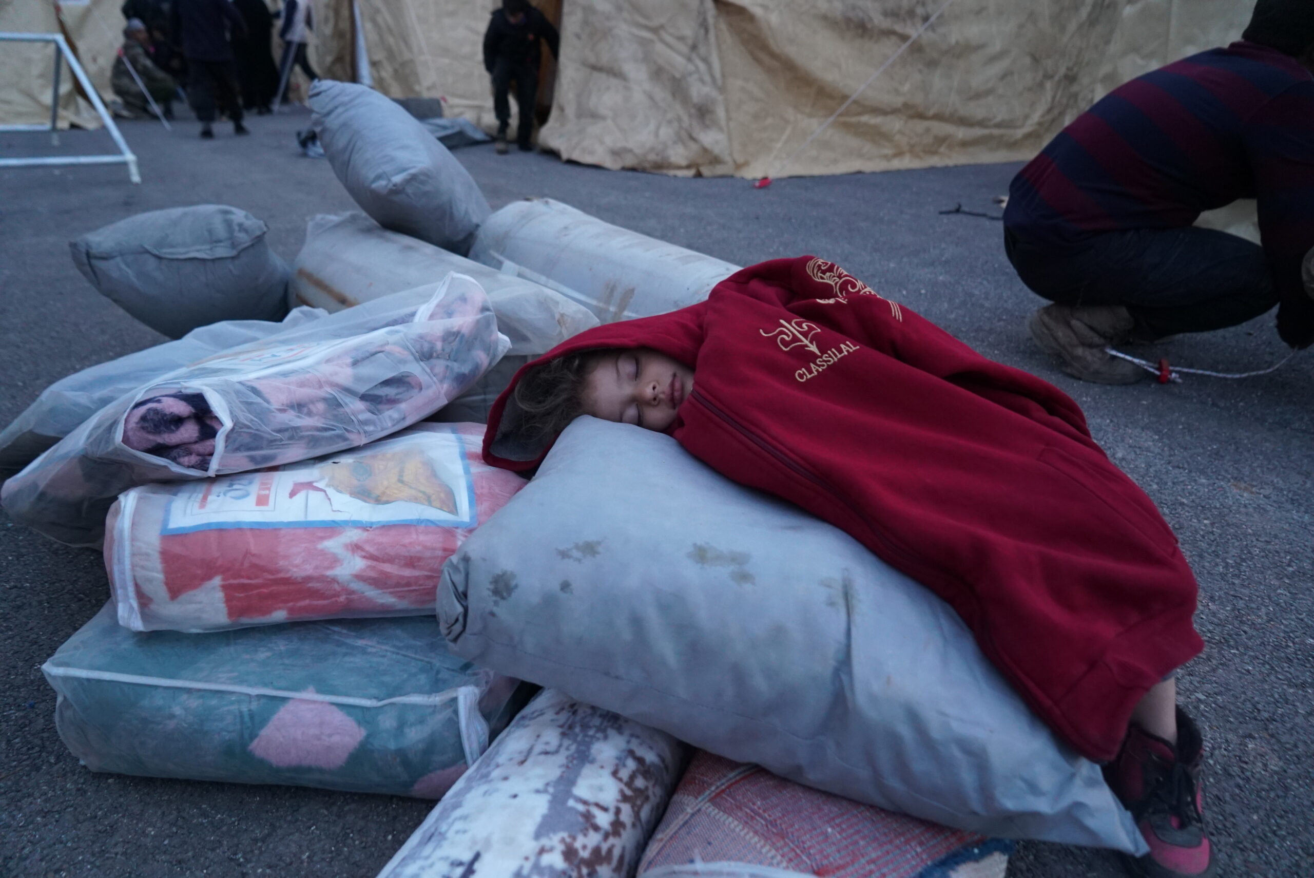 A baby sleep on blankets in a reception centre for earthquake victims near Aleppo, north-west Syria