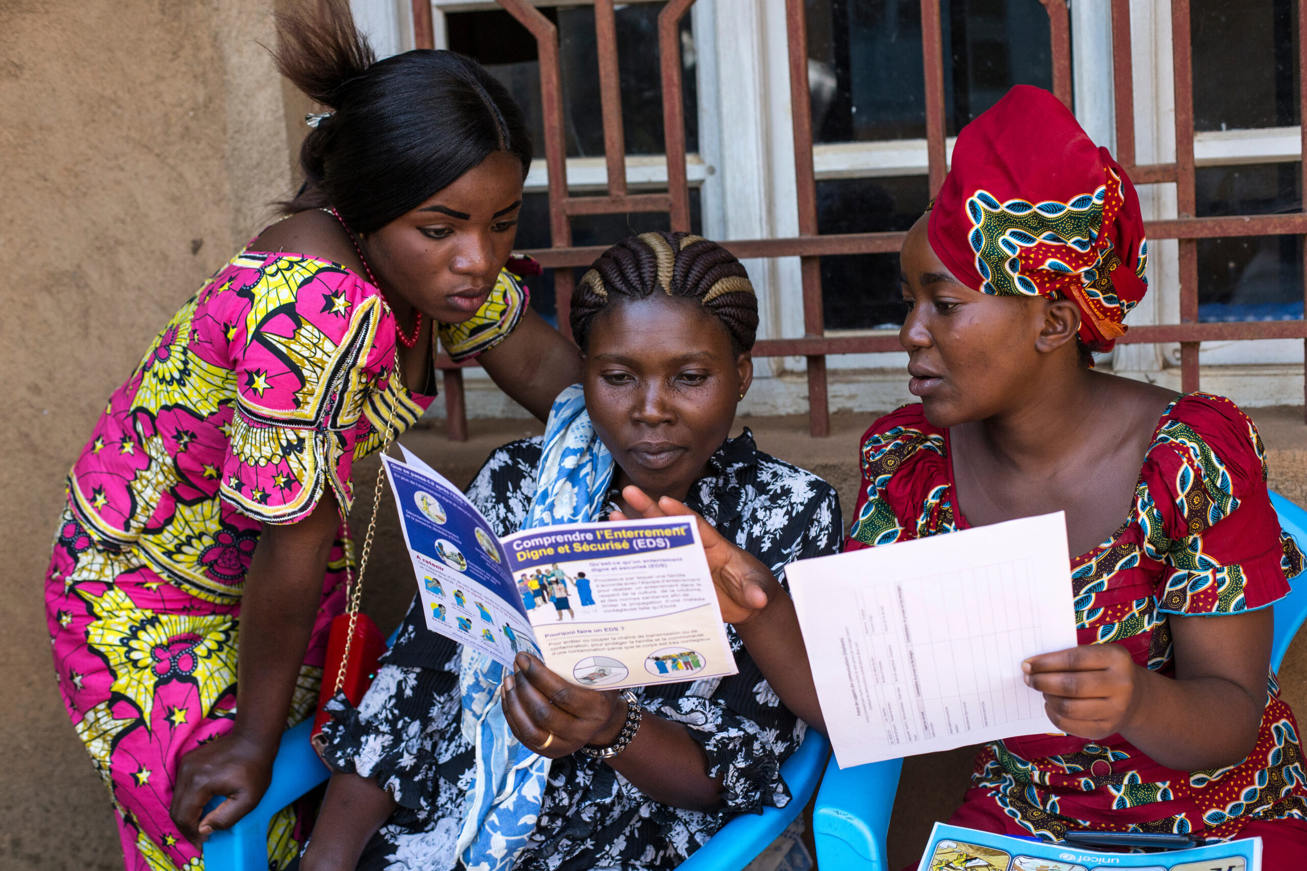 Women from the Somuma community group siting together and providing feedback on the new leaflets that is going to be distributed to the community about Ebola.