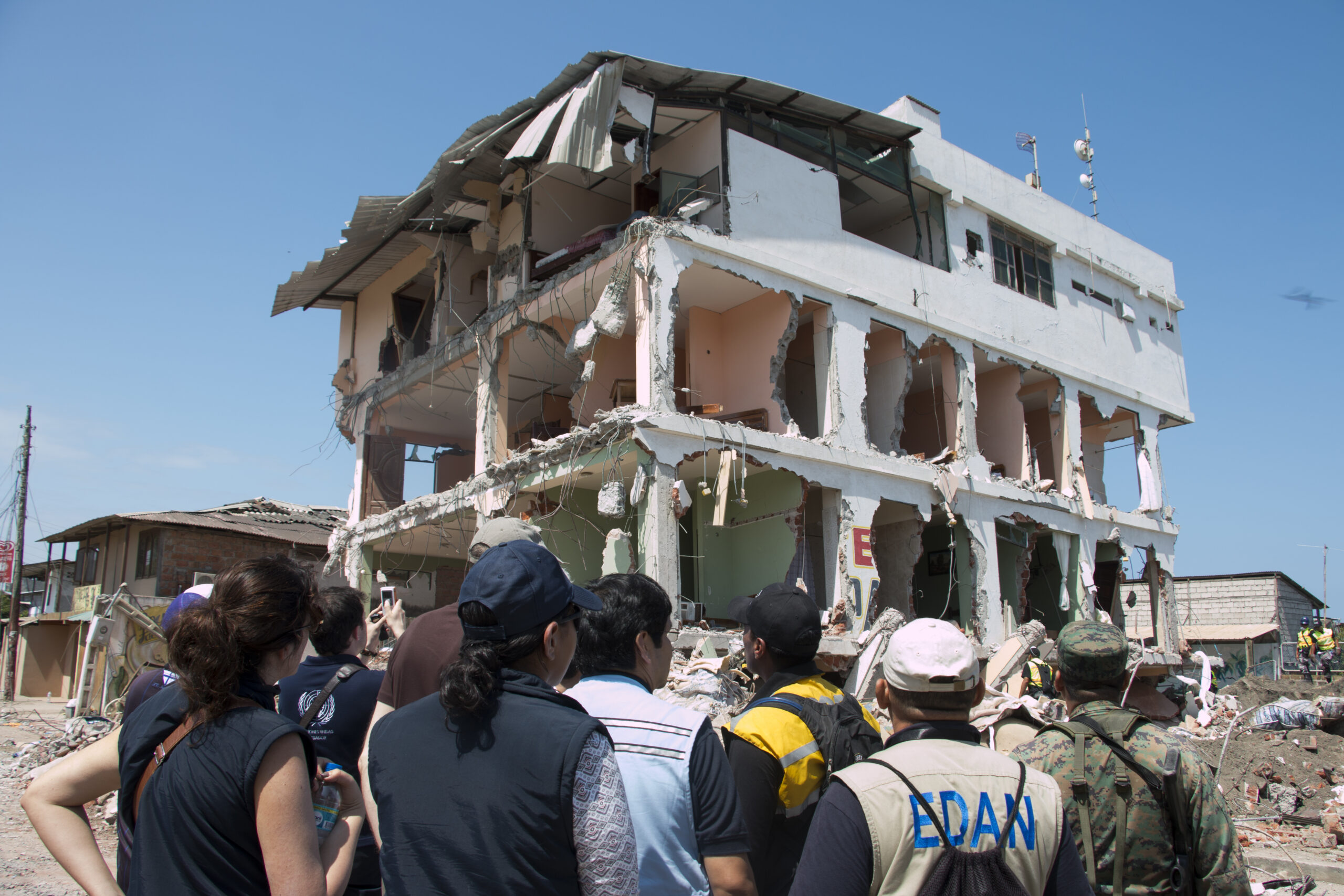 Humanitarian workers looking at a destroyed building